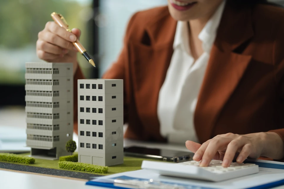Résidence moderne de 6 étages, façade blanche épurée avec balcons filants, entourée d'une végétation luxuriante